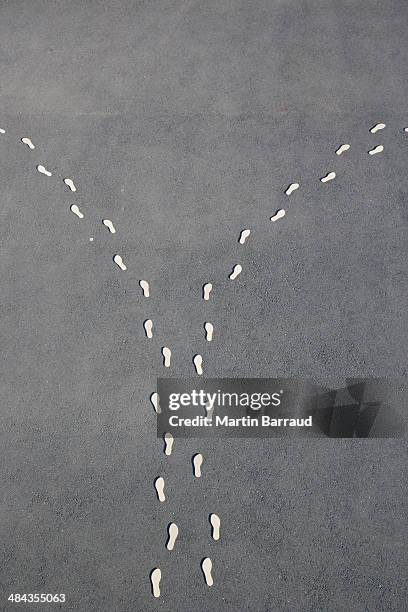 diverging line of footprints - diverging paths concept stock pictures, royalty-free photos & images
