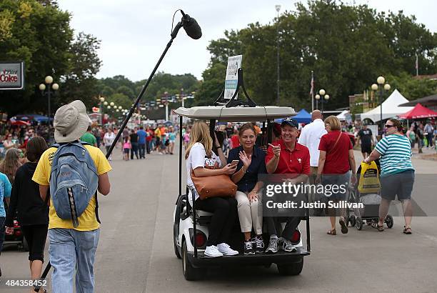 Republican presidential candidate and U.S. Sen. Lindsey Graham rides on the back of a golf cart with his sister Darline Graham Nordone during the...