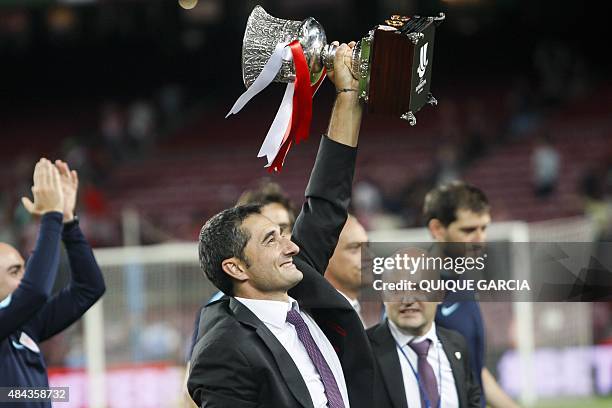 Athletic Bilbao's coach Ernesto Valverde raises the Supercup trophy after the Spanish Supercup second-leg football match FC Barcelona vs Athletic...