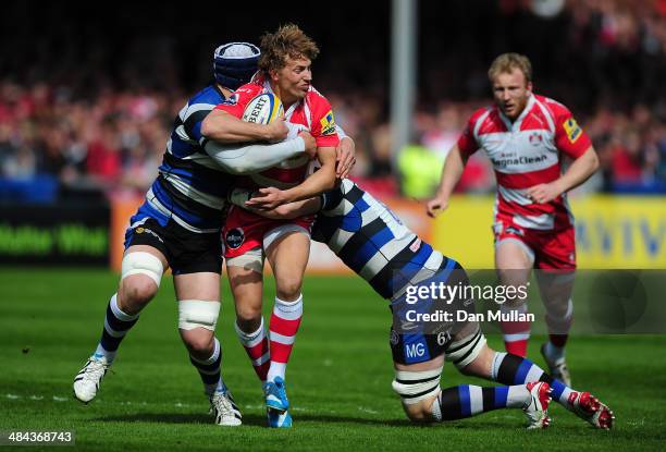 Billy Twelvetrees of Gloucester is tackled by Dave Attwood and Matt Garvey of Bath during the Aviva Premiership match between Gloucester and Bath at...