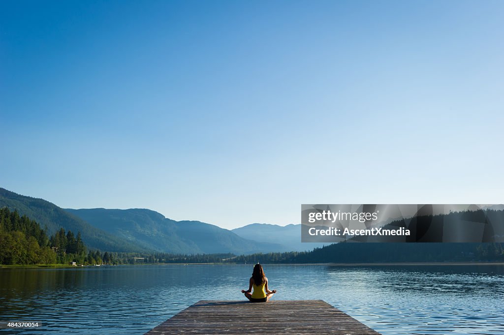 Einfache Pose besinnlichen Lakeside meditation bei Sonnenaufgang