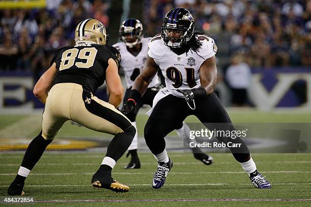 Josh Hill of the New Orleans Saints and Courtney Upshaw of the Baltimore Ravens line up during a preseason game at M&T Bank Stadium on August 13,...