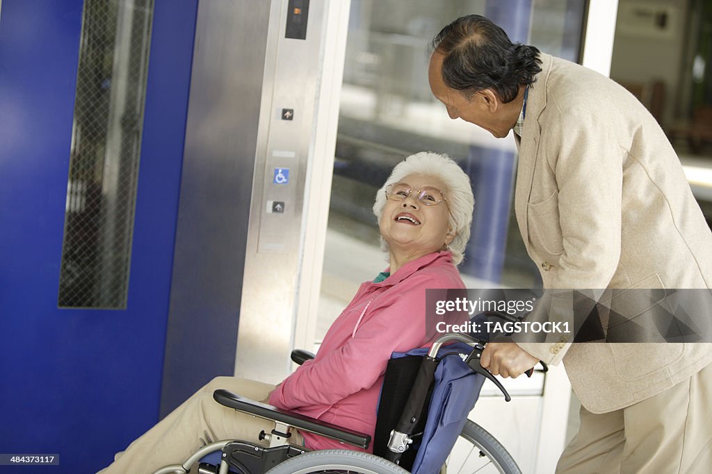 Wheelchaired wife and husband using an elevator