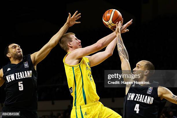 Brock Motum of the Boomers attempts to shoot past the defence of Everard Bartlett and Lindsay Tait of the Tall Blacks during the game two match...