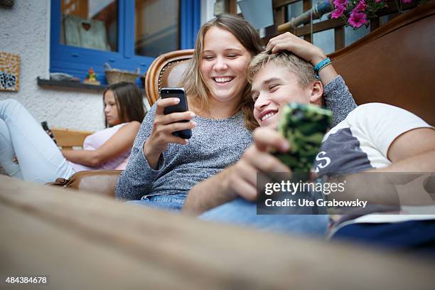 Germany Three youth sitting on a couch staying outside in the garden on August 10, 2015 in Bonn, Germany.