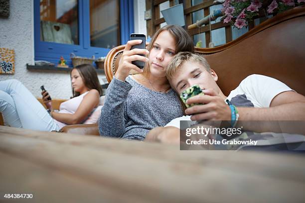 Germany Three youth sitting on a couch staying outside in the garden on August 10, 2015 in Bonn, Germany.