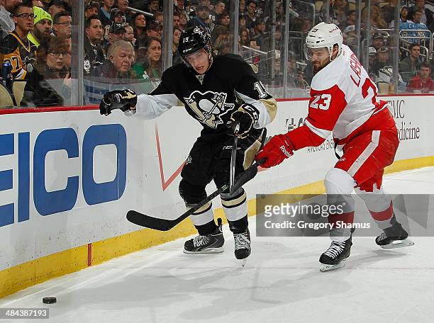 Beau Bennett of the Pittsburgh Penguins battles of the puck against Brian Lashoff of the Detroit Red Wings on April 9, 2014 at Consol Energy Center...