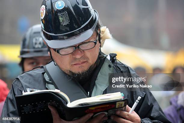 Director Shinji Higuchi looks at his storyboard during the filming of "Attack on Titan" on June 9, 2014 in Takahagi, Japan.