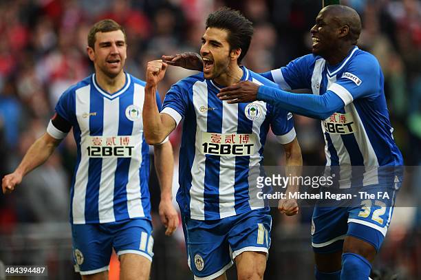 Jordi Gomez of Wigan Athletic celebrates with team-mates James McArthur and Marc-Antoine Fortune after scoring a goal from the penalty spot during...