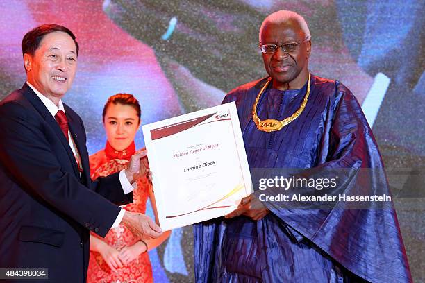 Liu Peng, Minister of Sports ot the People's Republic of China hands over the Golden Order of Merit to IAAF President Lamine Diack during the IAAF...