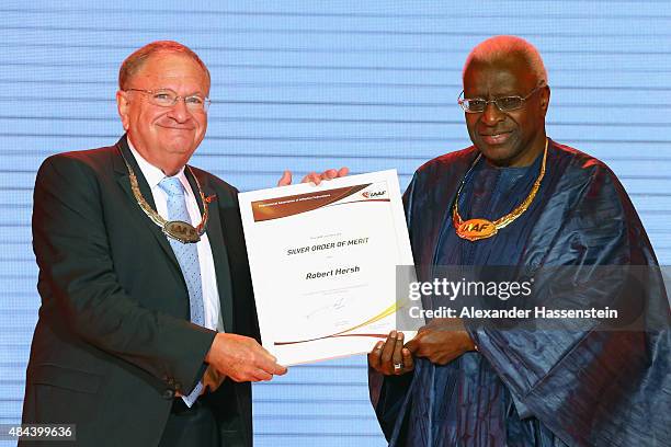 President Lamine Diack hands over the Silver Order of Merit to Robert Hersh during the IAAF Congress Opening Ceremony at the Great Hall of the People...