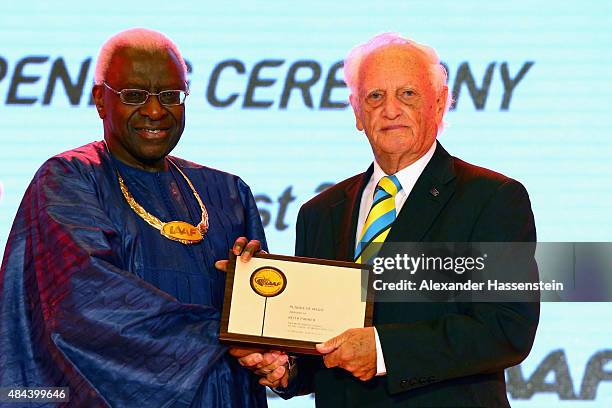 President Lamine Diack hand sover the Plaque of Merit to Keith Parker during the IAAF Congress Opening Ceremony at the Great Hall of the People at...