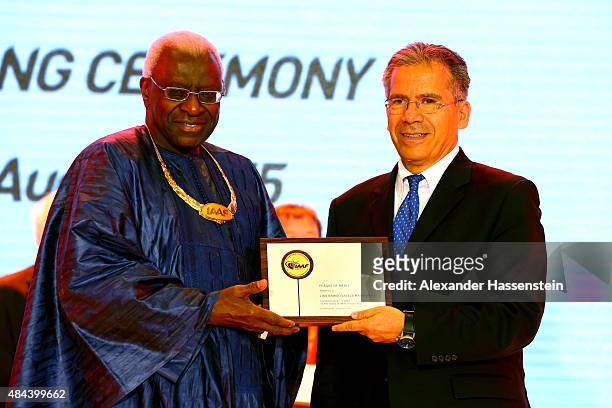President Lamine Diack hands over the Plaque of Merit to Lino Ramiro Varela Marmolejo during the IAAF Congress Opening Ceremony at the Great Hall of...