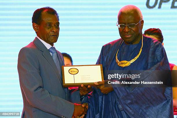 President Lamine Diack hand sover the Plaque of Merit to Vivian Gungaram during the IAAF Congress Opening Ceremony at the Great Hall of the People at...