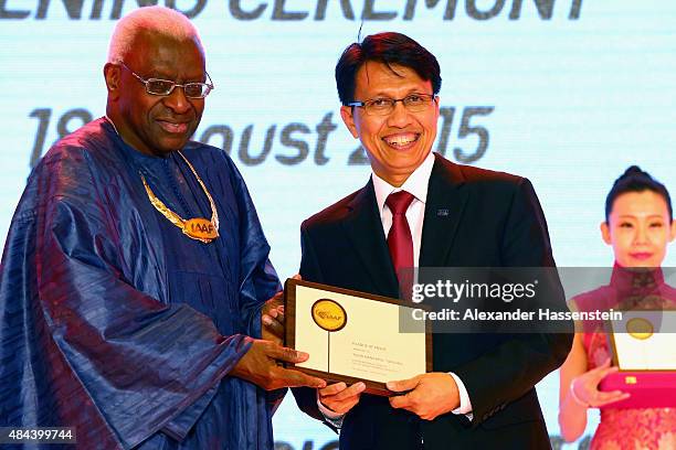 President Lamine Diack hand sover the Plaque of Merit to Tigor Mangapul Tanjung during the IAAF Congress Opening Ceremony at the Great Hall of the...