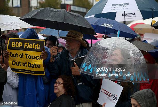 Protester holds a sign as republican presidential candidate and U.S. Sen. Marco Rubio speaks during the Iowa State Fair on August 18, 2015 in Des...