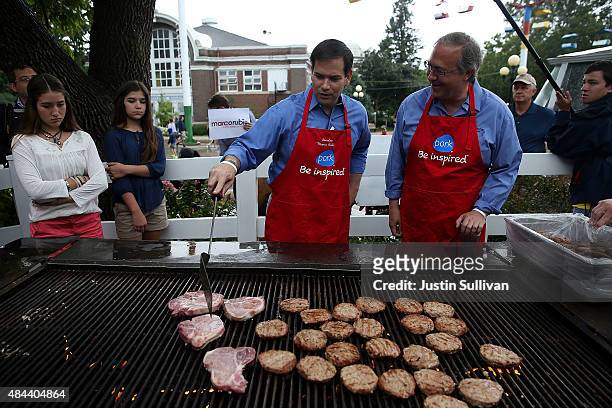 Republican presidential candidate and U.S. Sen. Marco Rubio mans the grill with U.S. Rep. David Young at the Iowa Pork Producers Pork Tent during the...