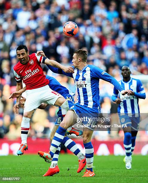 Santi Cazorla of Arsenal is challenged by Jack Collison of Wigan Athletic during the FA Cup Semi-Final match between Wigan Athletic and Arsenal at...