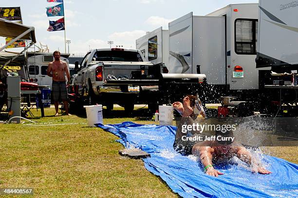 Fan slides on a tarp in the infield before the NASCAR Sprint Cup Series Bojangles' Southern 500 at Darlington Raceway on April 12, 2014 in...