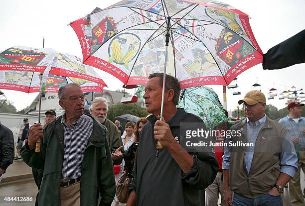 Republican presidential candidate and Ohio Gov. John Kasich talks with U.S. Sen. Chuck Grassley as he tours the Iowa State Fair on August 18, 2015 in...