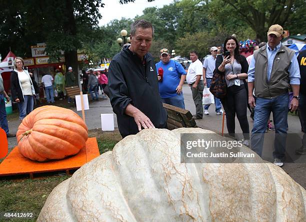 Republican presidential candidate and Ohio Gov. John Kasich looks at a giant pumpkin as he tours the Iowa State Fair on August 18, 2015 in Des...