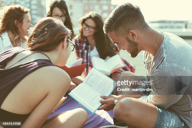 group of students reading books on the rooftop - summer school stockfoto's en -beelden