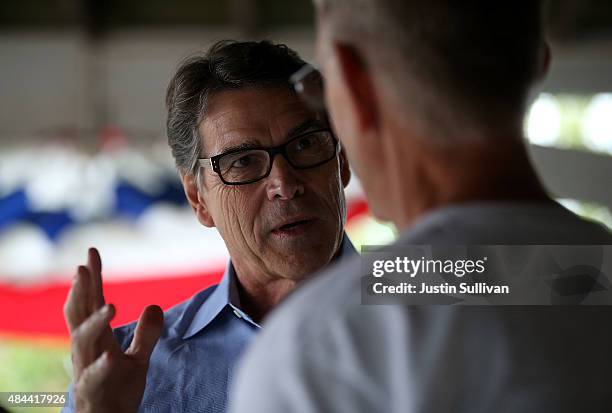 Republican presidential candidate and former Texas Gov. Rick Perry talks with a fairgoer as he tours the Iowa State Fair on August 18, 2015 in Des...