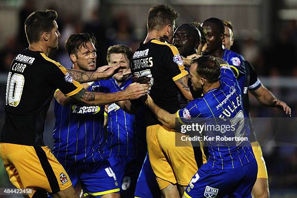 Liam Hughes of Cambridge United confronts Adebayo Akinfenwa of AFC Wimbledon as tempers flare during the Sky Bet League Two match between AFC...