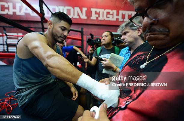 Former three division world champion boxer Abner Mares has his hands wrapped while taking questions from the media before a workout on August 18,...