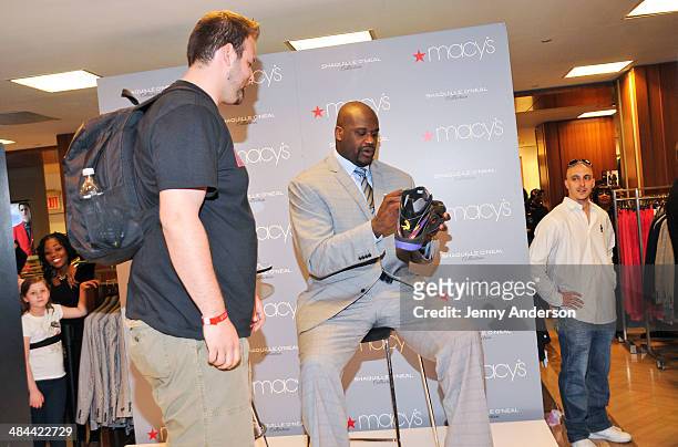 Shaquille O'Neal signs his size 22 shoe for a fan at the collection launch of his new men's clothing line at Macy's Herald Square on April 12, 2014...