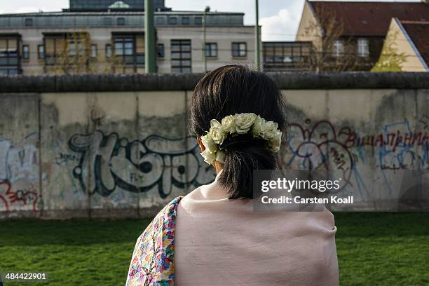 Myanmar pro-democracy leader Aung San Suu Kyi stays in front of the wall backside during a visit to the Berlin Wall Memorial on April 12, 2014 in...