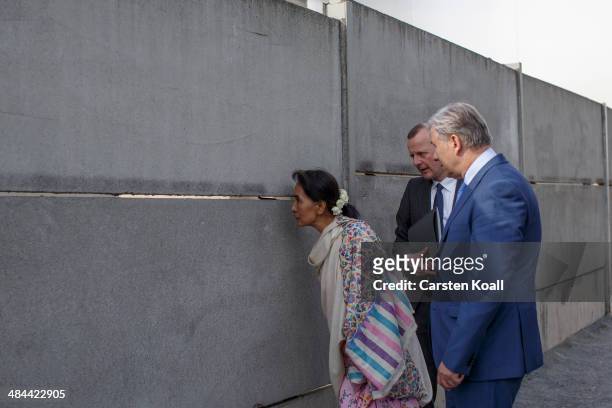 Myanmar pro-democracy leader Aung San Suu Kyi looks through the wall when Director of the Berlin Wall Memorial Axel Klausmeier and Berlin's Mayor...
