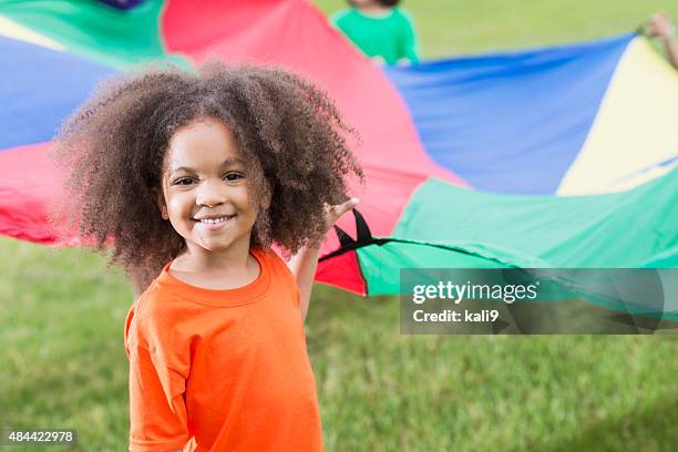 african american girl at summer camp holding parachute - summer camp kids stock pictures, royalty-free photos & images