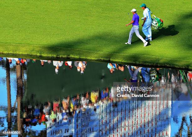 Jonas Blixt of Sweden walks to the 16th green with his caddie Zak Williamson during the third round of the 2014 Masters Tournament at Augusta...