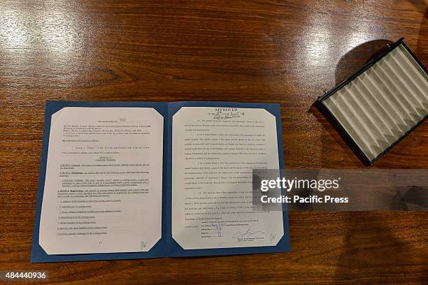 The signed document for Intro. 866 sits on the Mayor's Blue Room desk next to the now-empty tray that had contained 12 pens, each of which was used...