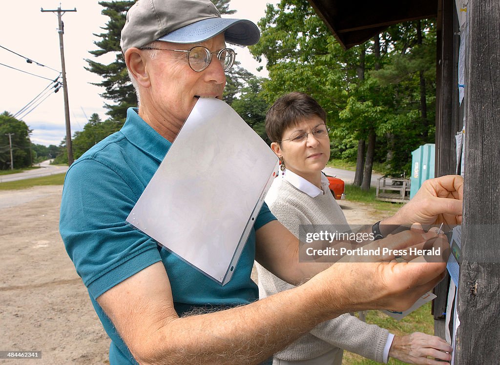 Arrowsic town officials Roger Heard, planning board chairman, and town clerk Heather Baker affix a t