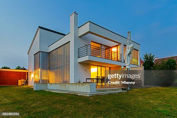 die moderne architektur haus und heim beleuchtet bei dämmerung - fensterladen stock-fotos und bilder