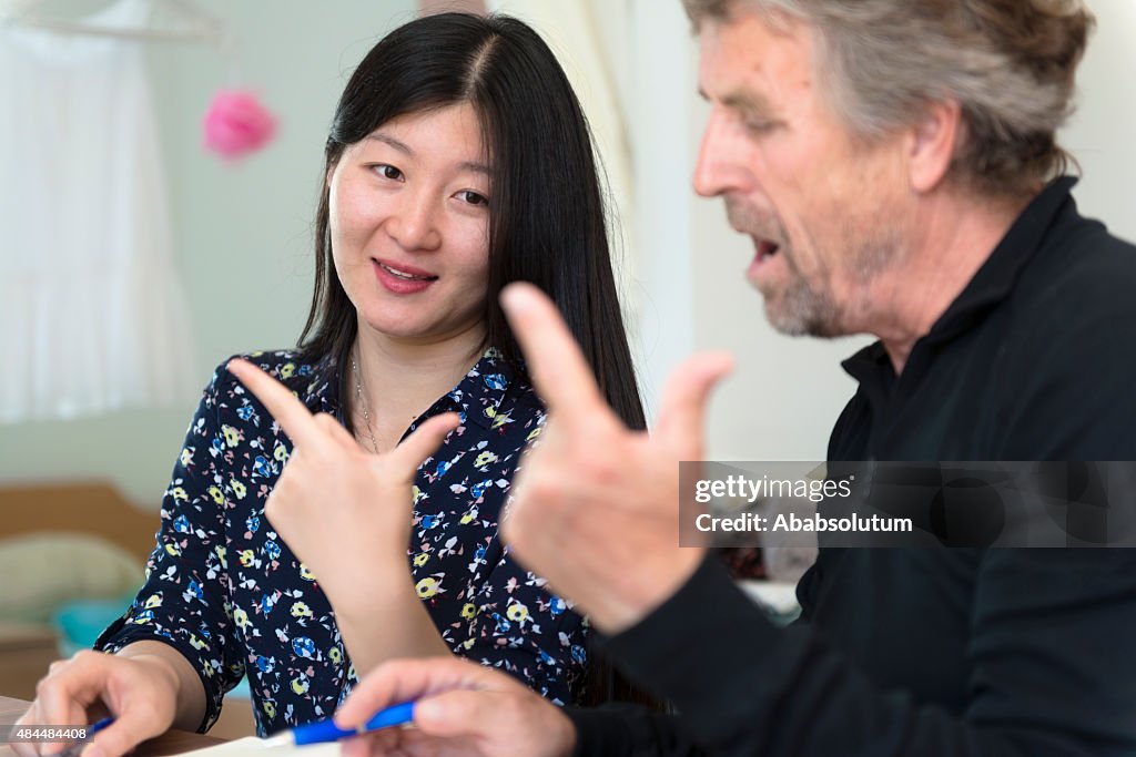 Chinese Woman Teaching Srenior Caucasian Chinese Numbers, Slovenia, Europe