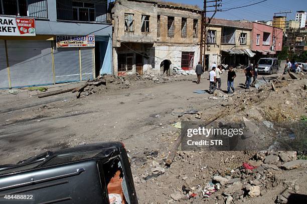 Picture taken on August 19, 2015 in Diyarbakir southeast Turkey shows people walking in a street of Silvan district in Diyarbakir after clashes...