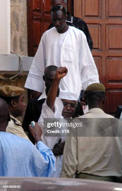 Chad's ex-dictator Hissene Habre raises his fist in victory as he leaves Dakar's courthouse escorted by prison guards 25 November 2005. A Senegal...
