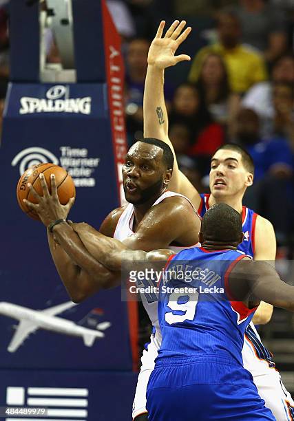Al Jefferson of the Charlotte Bobcats is trapped by teammates James Anderson and Byron Mullens of the Philadelphia 76ers during their game at Time...