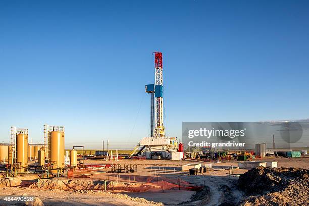 fracking fracking broca de torre de perforación en la pradera al atardecer - fracking fotografías e imágenes de stock