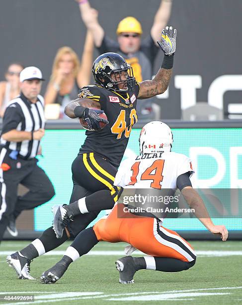 Eric Norwood of the Hamilton Tiger-Cats steps around quarterback Travis Lulay of the BC Lions for a touchdown during a CFL football game at Tim...