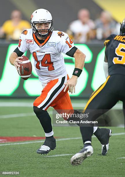 Travis Lulay of the BC Lions rolls out to make a play against the Hamilton Tiger-Cats during a CFL football game at Tim Hortons Field on August 15,...