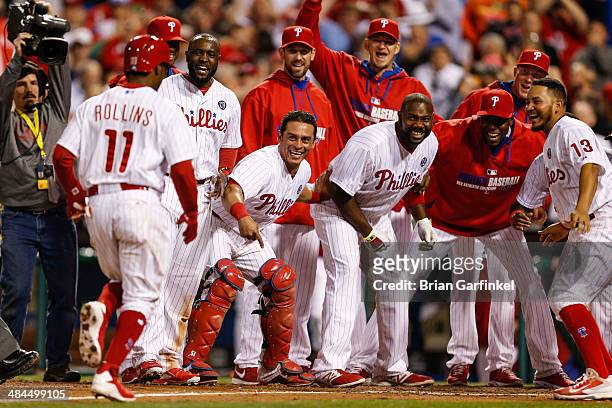 Jimmy Rollins of the Philadelphia Phillies is greeted by teammates at home plate after hitting a walk off home run in the tenth inning of the game...