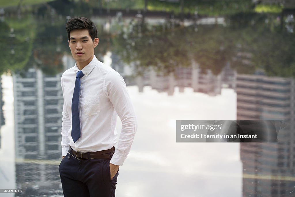Asian businessman standing in front of a lake