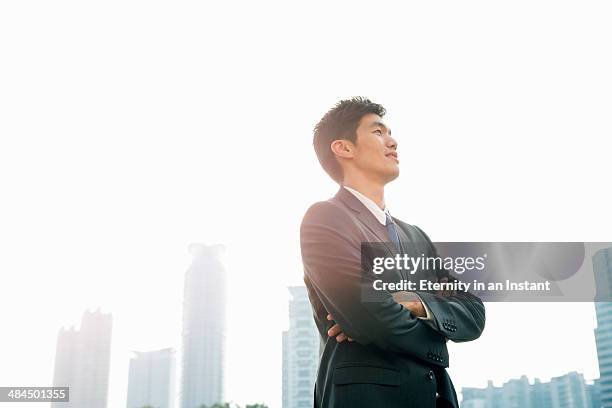 businessman looking up with arms folded - looking up ストックフォトと画像
