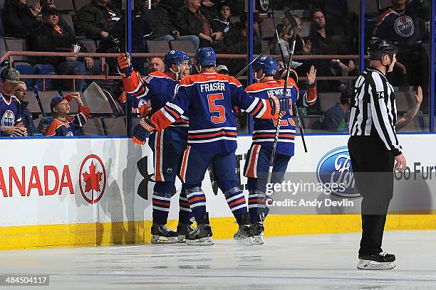 Will Acton, Mark Fraser and Matt Hendricks of the Edmonton Oilers celebrate after a goal in a game against the Vancouver Canucks on April 12, 2014 at...