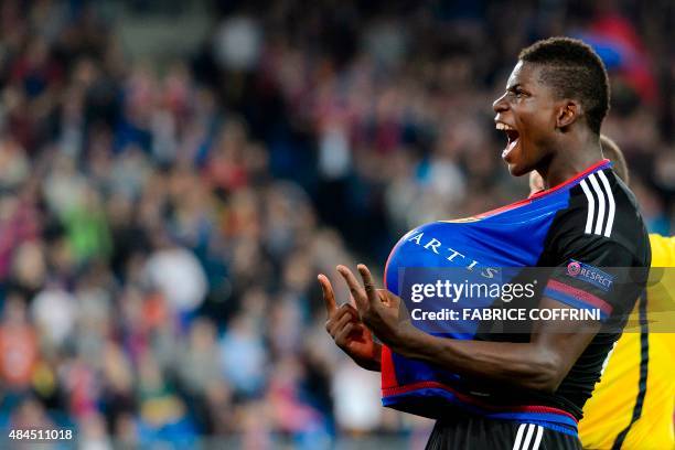 Basel's Swiss forward Breel Embolo flashes the "V for Victory" sign as he celebrates with a ball under his jersey after scoring the team's second...