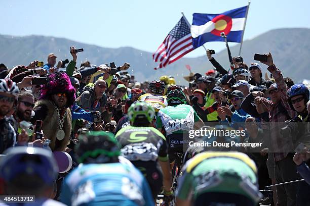 The group of the overall race leader Brent Bookwalter of United States riding for BMC Racing in the yellow jersey makes their way through the fans on...